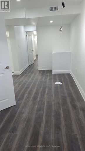 Clarington (Bowmanville) apartment for rent - A long hallway with a white door on the left and a white wall on the right.