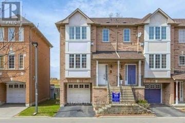 Mississauga (Hurontario) townhouse for rent - A row of townhouses with a blue sign in front of the first one.