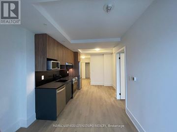 Hamilton (Central) condo for rent - A well-lit kitchen with dark wood cabinets and a white countertop.