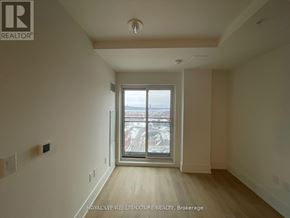 Hamilton (Central) condo for rent - A room with a large window and wooden flooring.