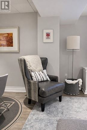 Hamilton (Waterdown) apartment for rent - A grey chair with a white pillow and a grey blanket is in the foreground of the image.