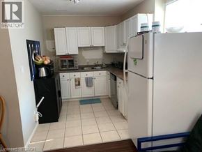 Waterloo apartment for rent - A kitchen with white cabinets and a black fridge.