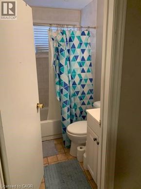 Waterloo apartment for rent - A bathroom with a toilet, a shower curtain and a rug.