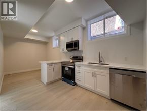 Kitchener apartment for rent - A kitchen with white cabinets and a black oven.
