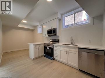 Kitchener apartment for rent - A kitchen with white cabinets and a black oven.