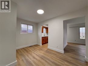 Kitchener apartment for rent - A spacious room with wooden flooring and a window.