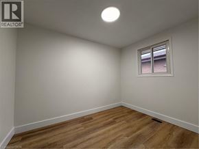 Kitchener apartment for rent - A room with a window and wooden flooring.
