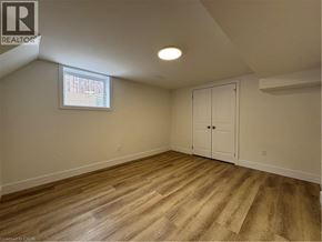 Kitchener apartment for rent - A room with wooden flooring and a window with blinds.