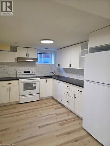 Hamilton apartment for rent - A kitchen with white appliances and wooden floors.