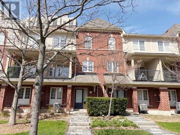 Oakville (Ro River Oaks) condo for rent - A red brick apartment building with a black door and a small tree in front.