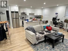 Kitchener apartment for rent - A living room with a couch, coffee table, and kitchen area in the background.