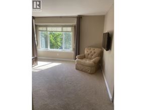 Coquitlam apartment for rent - A beige recliner chair is placed in a room with a window.