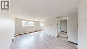 Grande Prairie apartment for rent - A spacious room with a window and a door leading to another room.