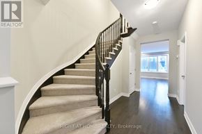 Ottawa apartment for rent - A staircase with a black railing and beige carpeted steps.