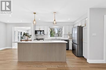 Centre Wellington (Fergus) apartment for rent - A modern kitchen with a central island and a refrigerator to the right.