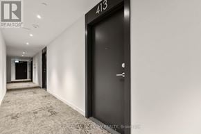 Toronto (Rouge) condo for rent - A hallway with a black door and a sign that says 413.