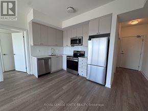 Clarington (Bowmanville) condo for rent - A kitchen with white cabinets and stainless steel appliances.