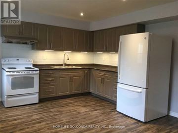 Mississauga (Erin Mills) apartment for rent - A white refrigerator stands in a kitchen with wooden cabinets and a white stove.