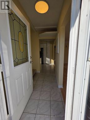 Hamilton (Bonnington) apartment for rent - A hallway with a white door and a glass window with a clock on it.