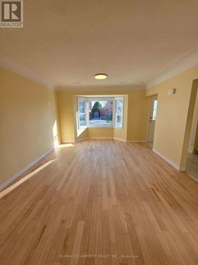 Hamilton (Bonnington) apartment for rent - A room with wooden flooring and a window showing an outdoor view.