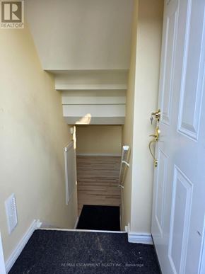 Hamilton (Bonnington) apartment for rent - A hallway with a door on the right and a staircase on the left.