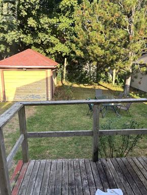 Kingston (Central City East) apartment for rent - A wooden deck with a table and chairs overlooking a backyard.