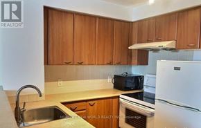 Toronto (Woburn) condo for rent - A kitchen with wooden cabinets and a white refrigerator.