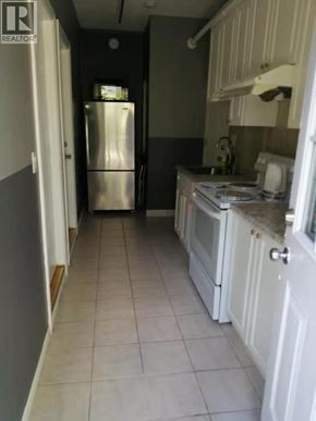 Burnaby apartment for rent - A kitchen with white cabinets and a stainless steel refrigerator.