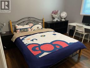 Burnaby apartment for rent - A bed with a blue comforter and pillows in a room.