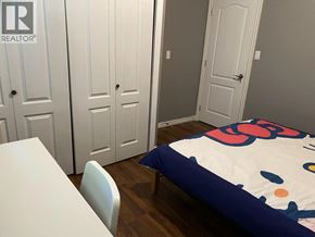 Burnaby apartment for rent - A bedroom with a bed, a table and chairs, and a wardrobe.