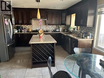 Burnaby apartment for rent - A kitchen with a table and chairs in the foreground.