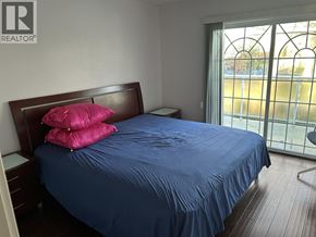 Burnaby apartment for rent - A bed with a blue sheet and two pink pillows.