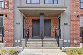 Waterloo townhouse for rent - The front entrance of a building with a black door and steps leading up to it.