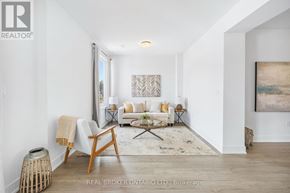 Waterloo townhouse for rent - A living room with a white couch, a wooden chair, and a rug.