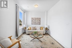 Waterloo townhouse for rent - A living room with a white couch, a coffee table, and a painting on the wall.