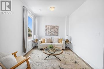 Waterloo townhouse for rent - A living room with a white couch, a coffee table, and a painting on the wall.