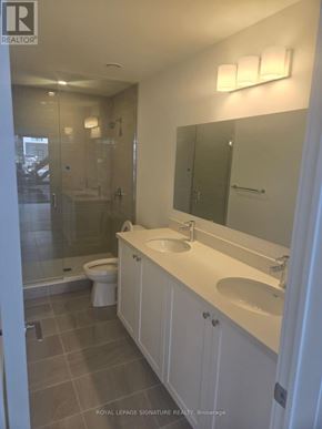 Clarington (Bowmanville) condo for rent - A white bathroom with a sink, toilet and shower.