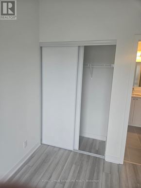 Clarington (Bowmanville) condo for rent - A white sliding door in a room with wooden flooring.
