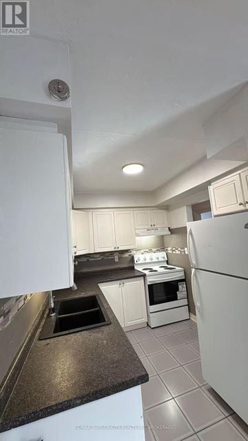 St. Catharines (Western Hill) condo for rent - A kitchen with white appliances and a black counter top.