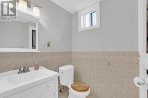Vaughan (East Woodbridge) apartment for rent - A white bathroom with a toilet, sink, and mirror.
