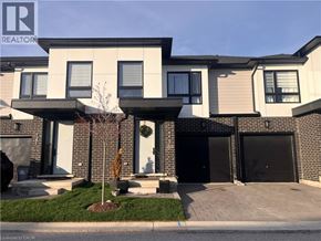 Komoka townhouse for rent - A house with a realtor sign in front.