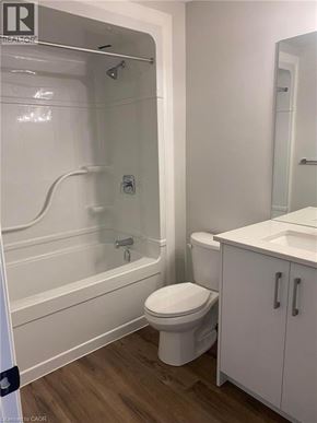Komoka townhouse for rent - A white bathroom with a toilet, sink, and bathtub.