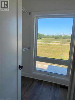 Komoka townhouse for rent - A window with a view of a field and a road.