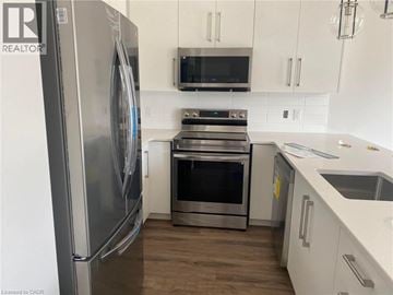 Komoka townhouse for rent - A modern kitchen with a stainless steel refrigerator and oven.