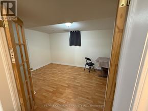 Toronto (Rouge) apartment for rent - A room with wooden flooring and a chair.