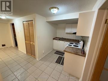 Toronto (Rouge) apartment for rent - A kitchen area with a stove top oven and a counter.