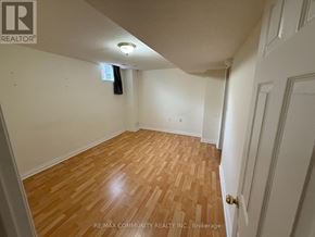 Toronto (Rouge) apartment for rent - A room with wooden flooring and white walls, with a door on the right side.