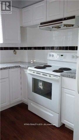Richmond Hill (Harding) triplex for rent - A white stove in a kitchen with white cabinets.