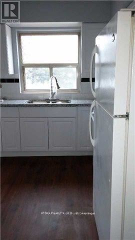 Richmond Hill (Harding) triplex for rent - A kitchen with a white refrigerator and a window above the sink.