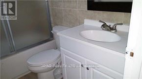Richmond Hill (Harding) triplex for rent - A white toilet sits next to a white sink in a bathroom.